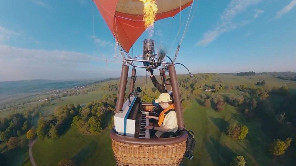 Joe Jenkins playing piano in a balloon