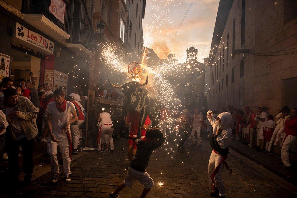 People are chased by the 'Toro de Fuego' through the streets during the opening day of the San Fermin Running of the Bulls fiesta on in Pamplona, Spain, 6 July 2022