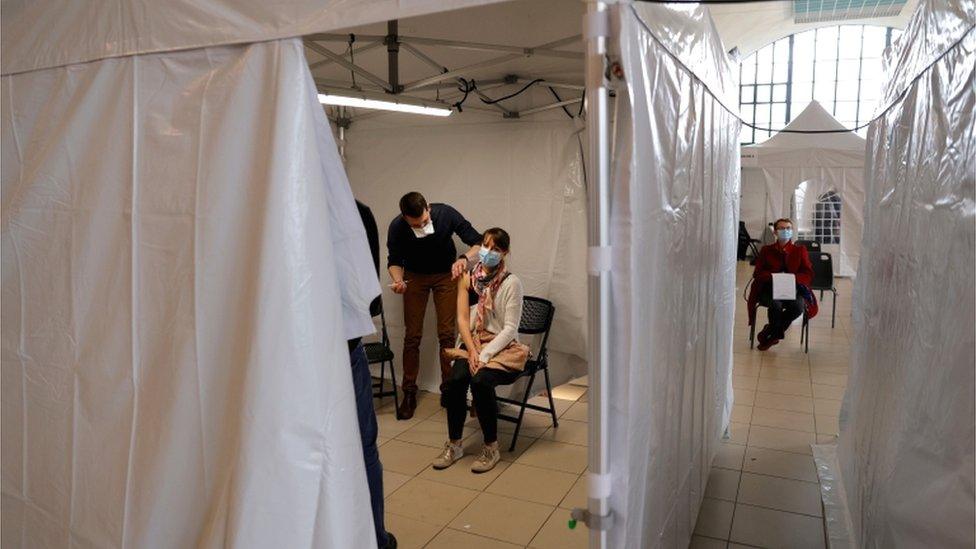 Image shows a woman being vaccinated in Nice, France