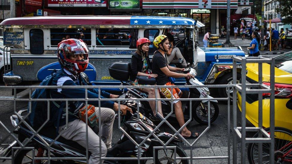 Filipinos at a traffic light in Manila