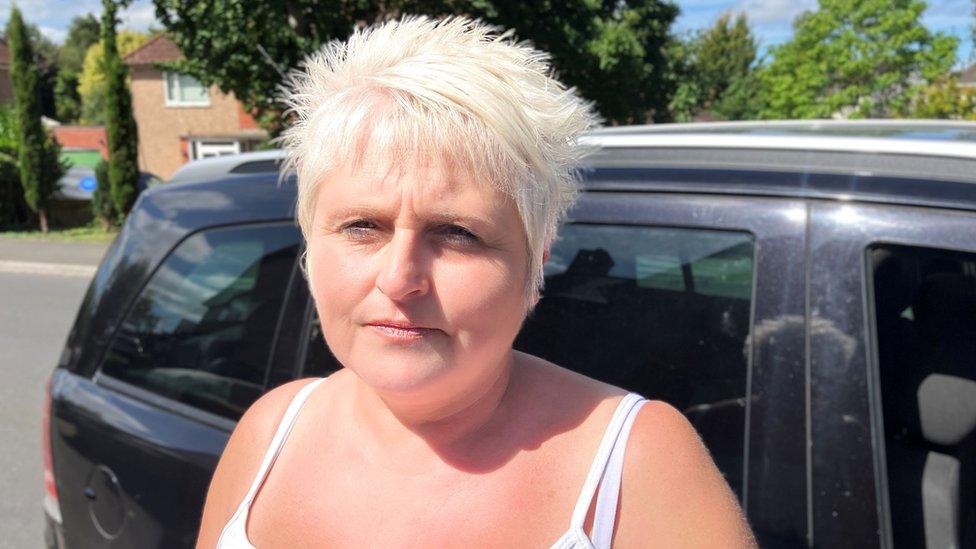 Head and shoulders shot of Dawn Sanders outside in a white vest top and with short blonde hair