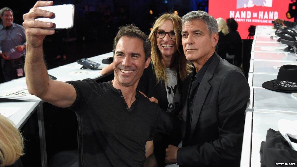 Will & Grace actor Eric McCormack takes a selfie with George Clooney and Julia Roberts at the telethon in L.A.