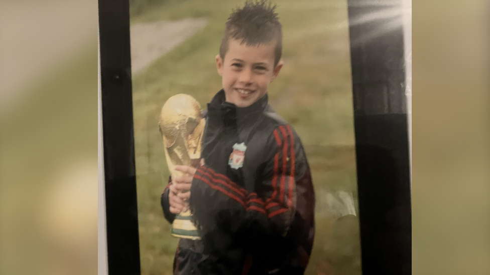 Neco Williams as a boy, holding a replica World Cup