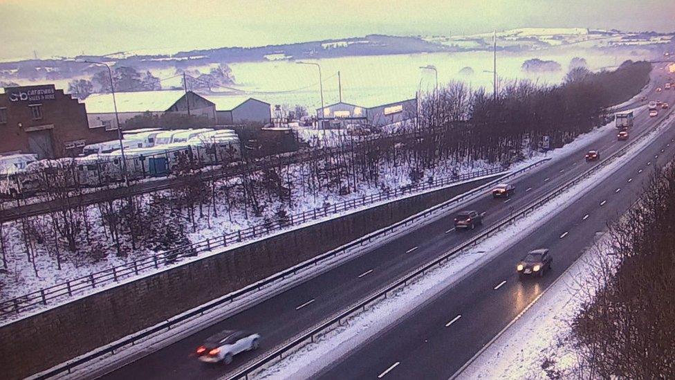 Traffic moving among snow on the A55