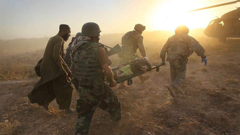 Coalition forces tend to the wounded during fighting near Marja, Afghanistan, in 2010