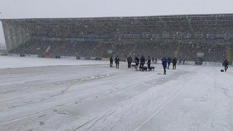 Staff clear pitch in snow