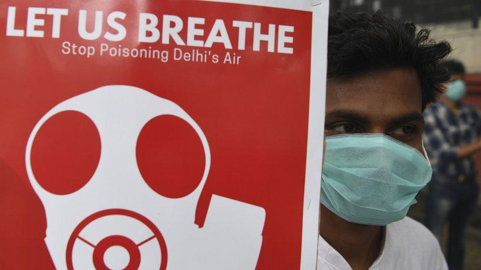 A demonstrator in Delhi holding a sign reading: Let us breathe