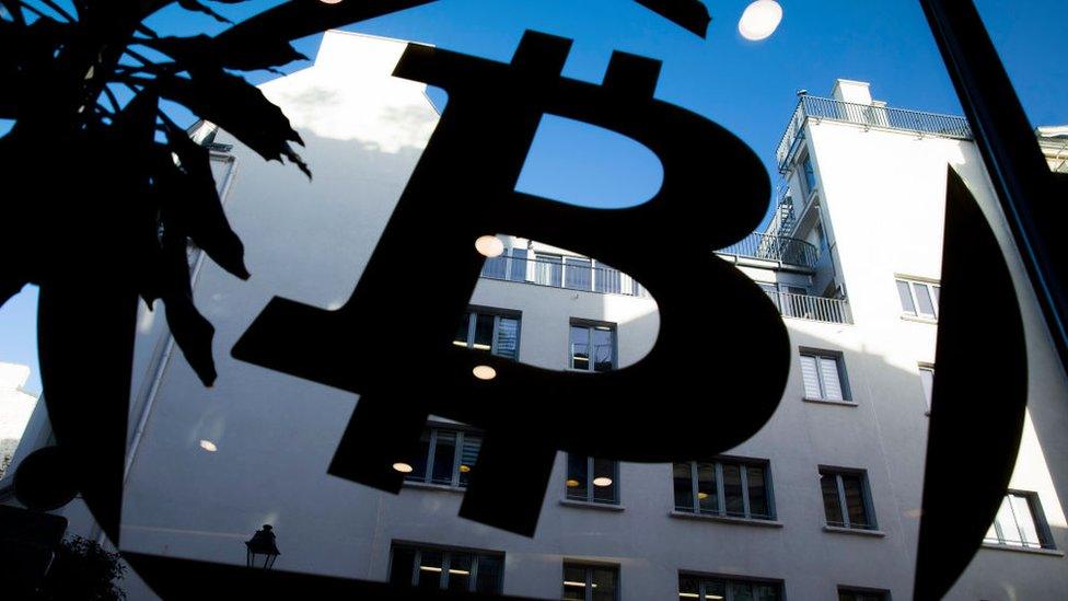 A bitcoin logo on a window at La Maison du Bitcoin in Paris