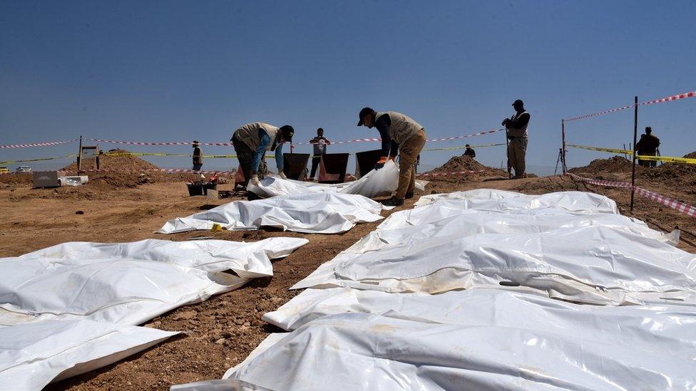 Iraqi forensic personnel exhumes bodies at a mass grave where inmates of Badoush prison were killed by the Islamic State group, in al-Humaydat village, western Mosul, Iraq (13 June 2021)