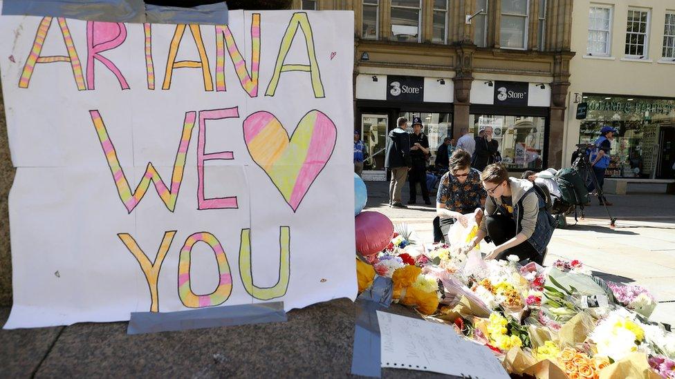 Flowers are left in St Ann's Square, Manchester