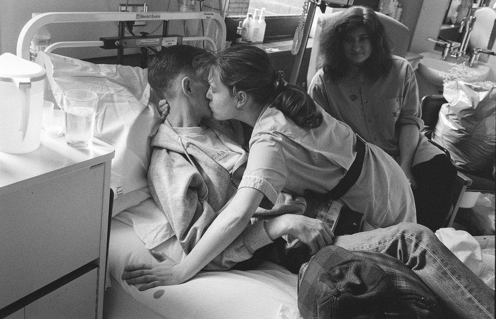 A nurse kisses a young patient.