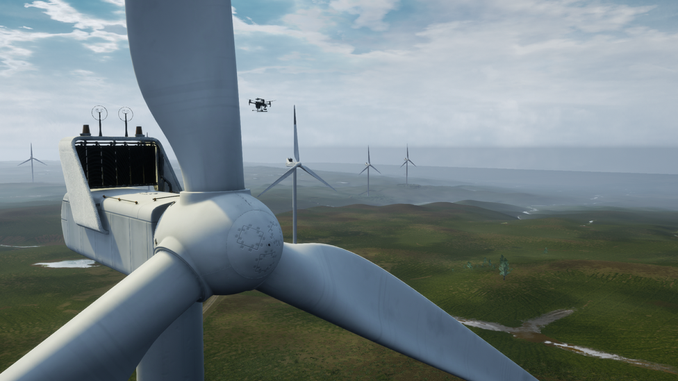 A drone flies next to a simulated wind turbine