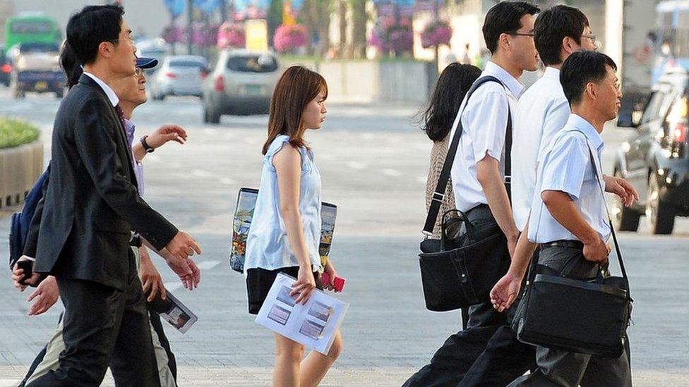 Koreans crossing a road on their way to work