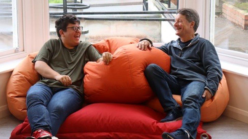 A mentor sitting in a bean bag with a young person