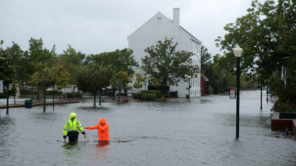 Residents walk in flooded streets as the Neuse River floods its banks during Hurricane Florence