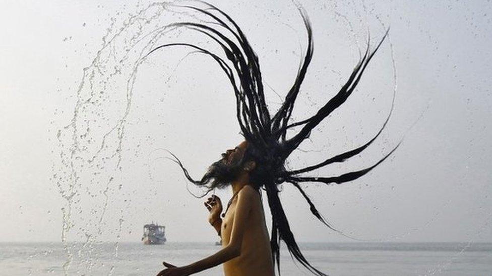 A Hindu holy man takes a dip at the confluence of the river Ganges and the Bay of Bengal near Calcutta on January 13, 2015.