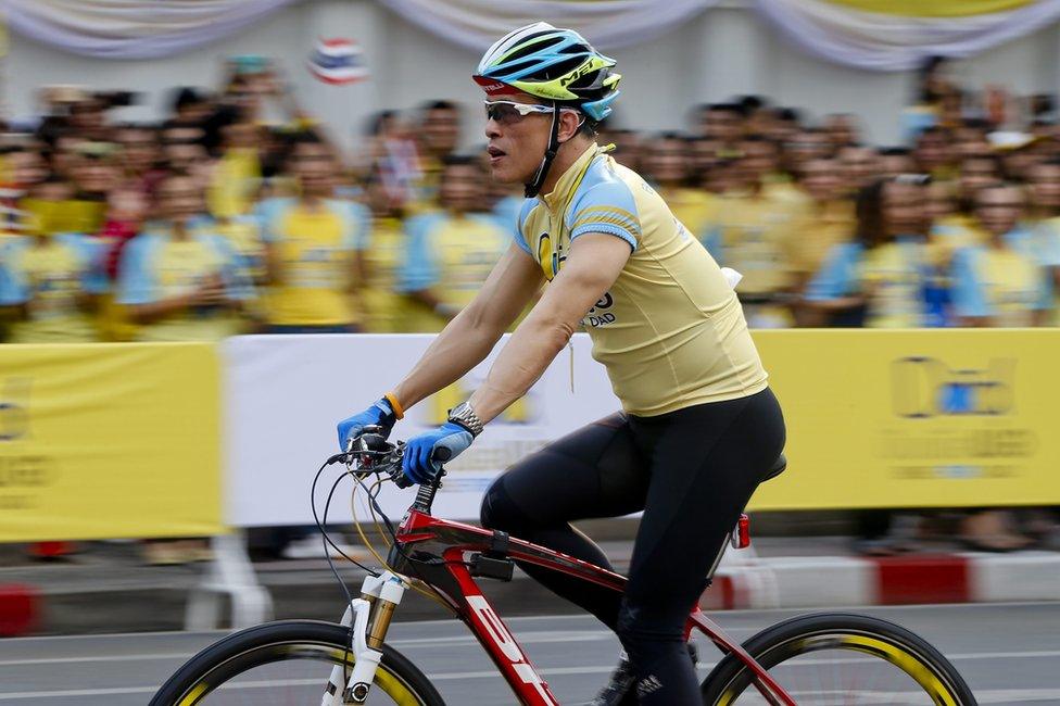 A photo taken with slow shutter speed shows Thai Crown Prince Maha Vajiralongkorn cycling past well-wishers during the Bike for Dad, mass bicycle ride campaign held to celebrate the 88th birthday of Thai King Bhumibol Adulyadej in Bangkok, Thailand, 11 December 2015.