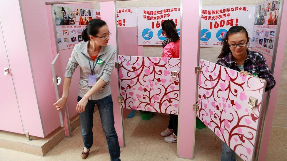 Women students using pink cubicles containing urinals with a sign instructing women how to urinate standing, at a toilet in Shanxi Normal University in Xian, in northwest China's Shanxi province (September 26, 2010)