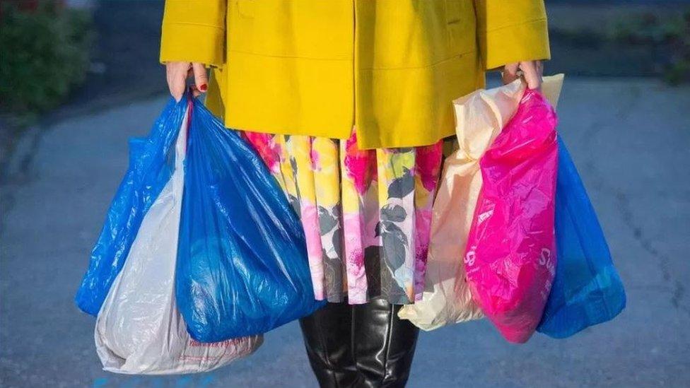 Woman carrying bright plastic bags