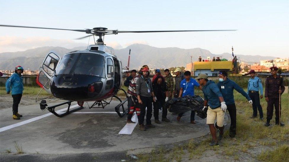 A body is removed from a helicopter in Kathmandu, Nepal (14 Oct 2018)