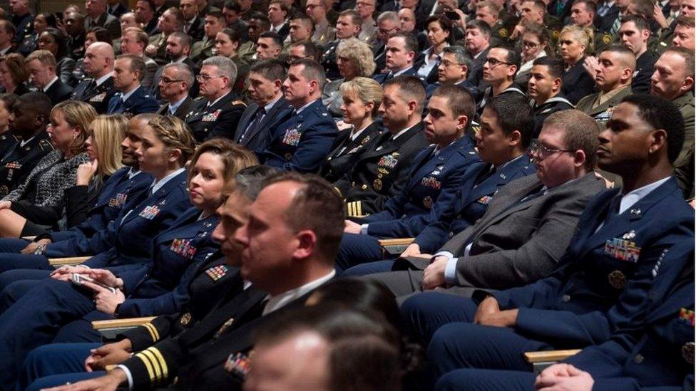 Rows of military members sit in audience of Donald Trump speech.