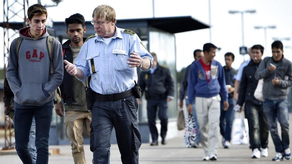 Refugees speak with a Danish policeman after arriving in Rodby, southern Denmark 7 September 2015.