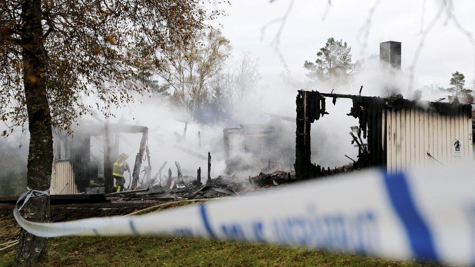 A firefighter works to extinguish a fire that broke out early in the morning at an accommodation for asylum seekers, near Munkedal in Sweden October 20, 2015.