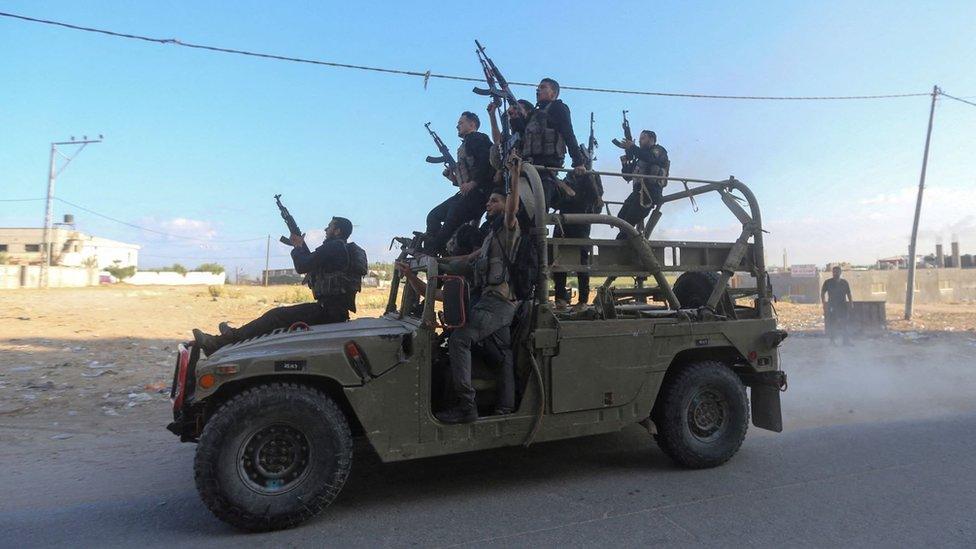 Palestinian militants ride an Israeli military vehicle that was seized by gunmen who infiltrated areas of southern Israel, in the northern Gaza Strip October 7, 2023.