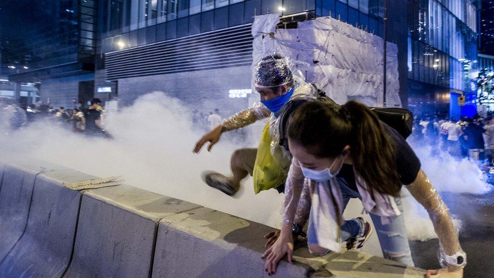 Pro-democracy activists run away during a demonstration in Hong Kong on September 28, 2014.