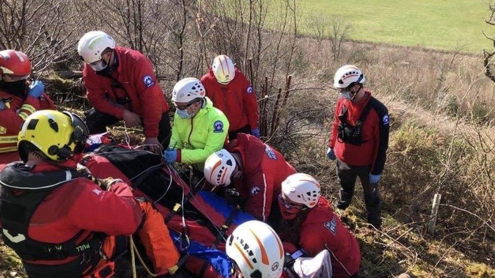 Y tîm achub mynydd gyda'r para-gleidiwr