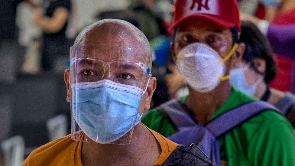 Commuters queue at a bus station a day before the government reimposes a strict lockdown to curb the spread of the coronavirus, on August 3, 2020 in Paranaque, Metro Manila