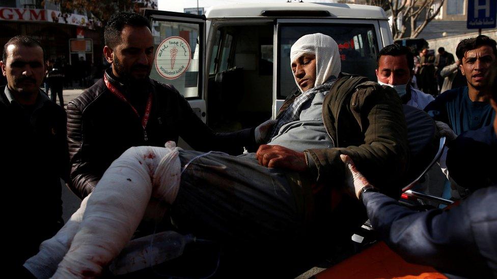 a heavily bandaged man being lifted from a stretcher