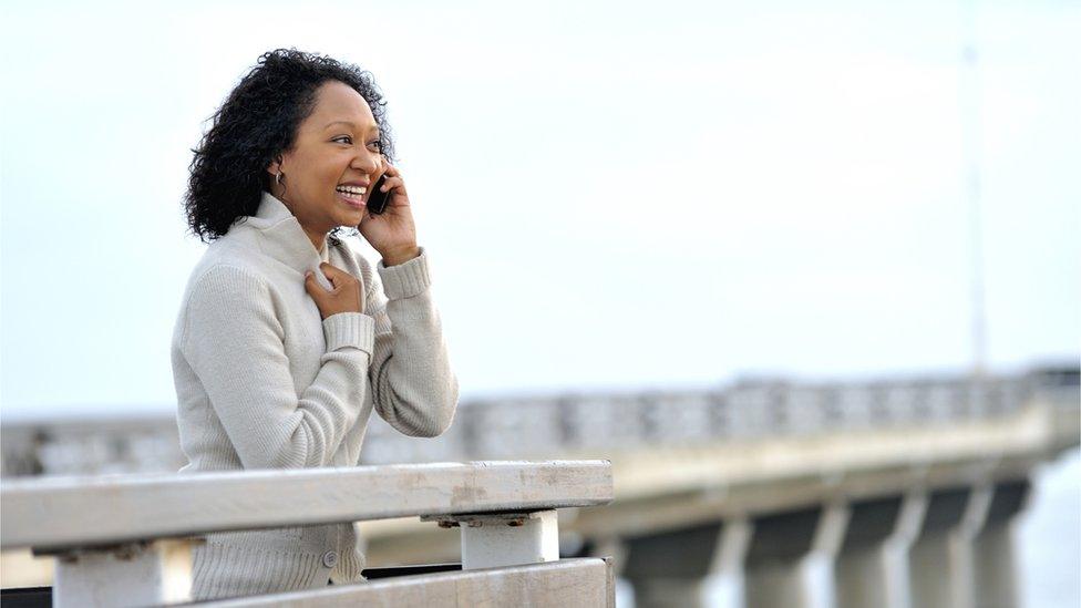 A woman talking on a phone on Port Elizabeth's pier, South Africa