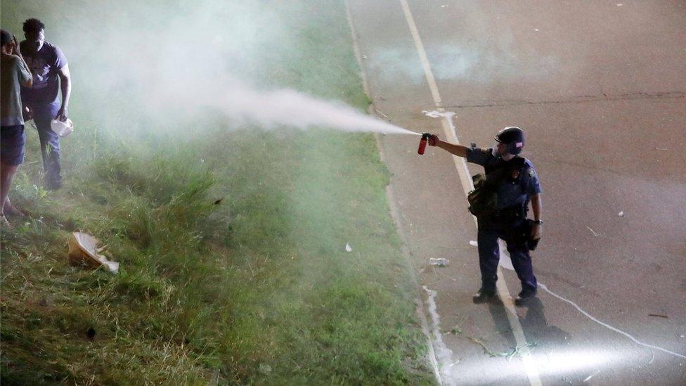 A police officer uses pepper spray as people gather on Interstate 94 to protest the fatal shooting of Philando Castile by Minneapolis area police during a traffic stop, in St. Paul, Minnesota, U.S., July 9, 2016.