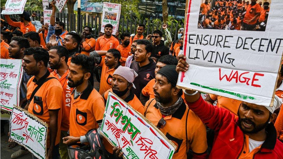 Delivery workers of Swiggy, an Indian food-delivery startup, hold placards during a demonstration demanding a hike in their remuneration, in Kolkata, on November 22, 2022. They also demanded that the company should guarantee health and accidental benefits for the delivery workers.