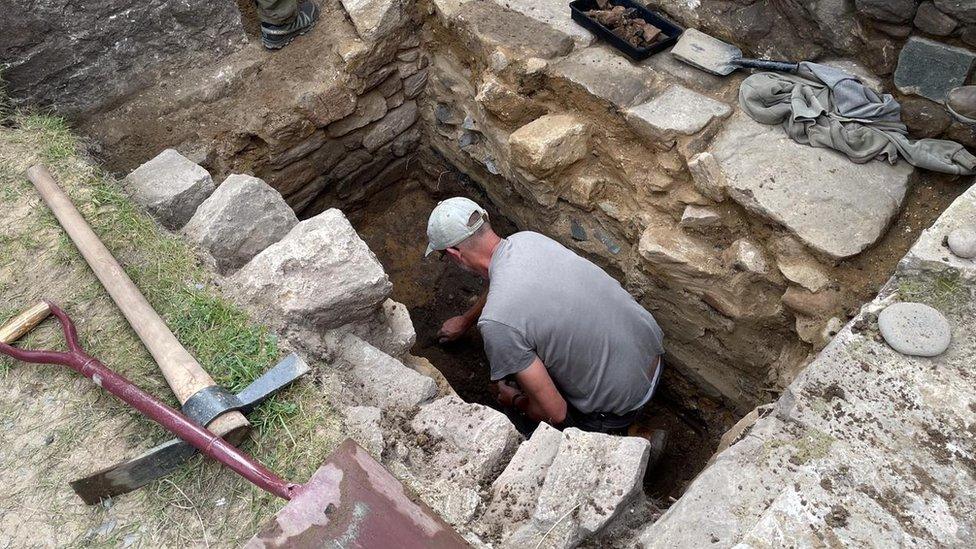 Volunteer excavating the Roman fort wall