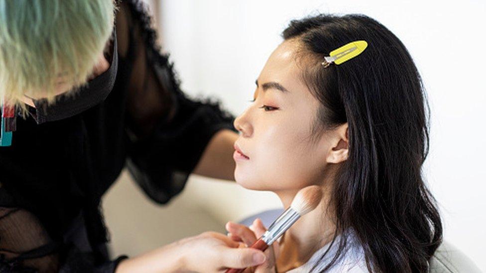 A women with makeup being put on her face