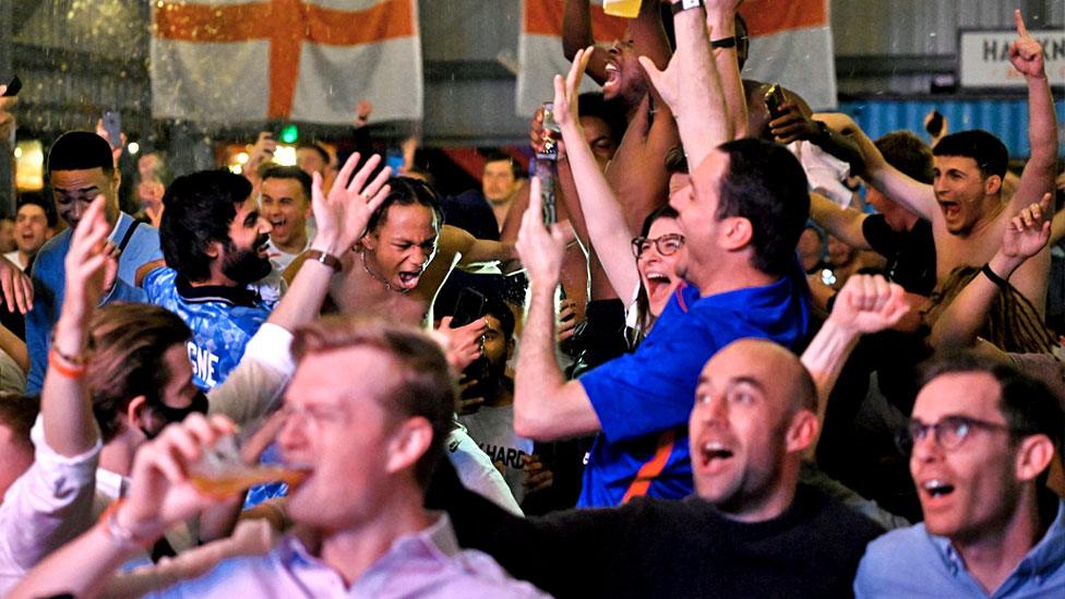 Fans celebrate as they watch a live broadcast of the semi-final match between England and Denmark at Hackney Bridge