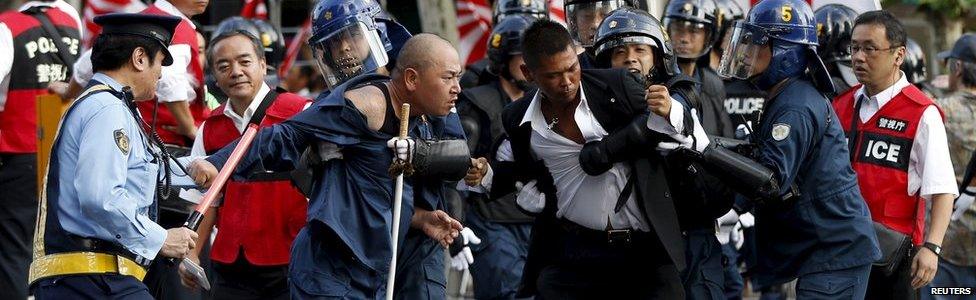 Right-wing activists jostle with riot police officers near Yasukuni Shrine in Tokyo, August 15, 2015