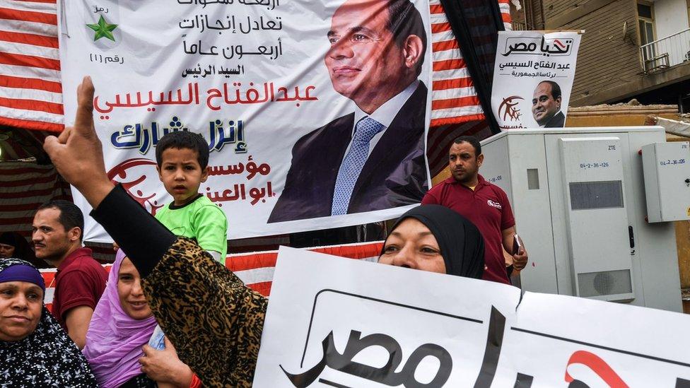 A supporter of Abdul Fattah al-Sisi makes a victory gesture outside a polling station in Giza, Cairo (28 March 2018)