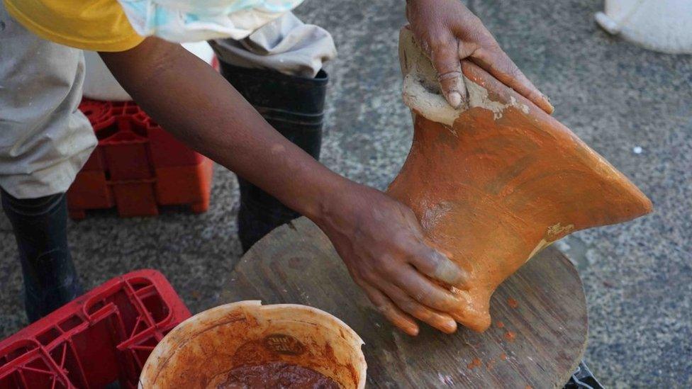 A traditional coal pot being made by hand