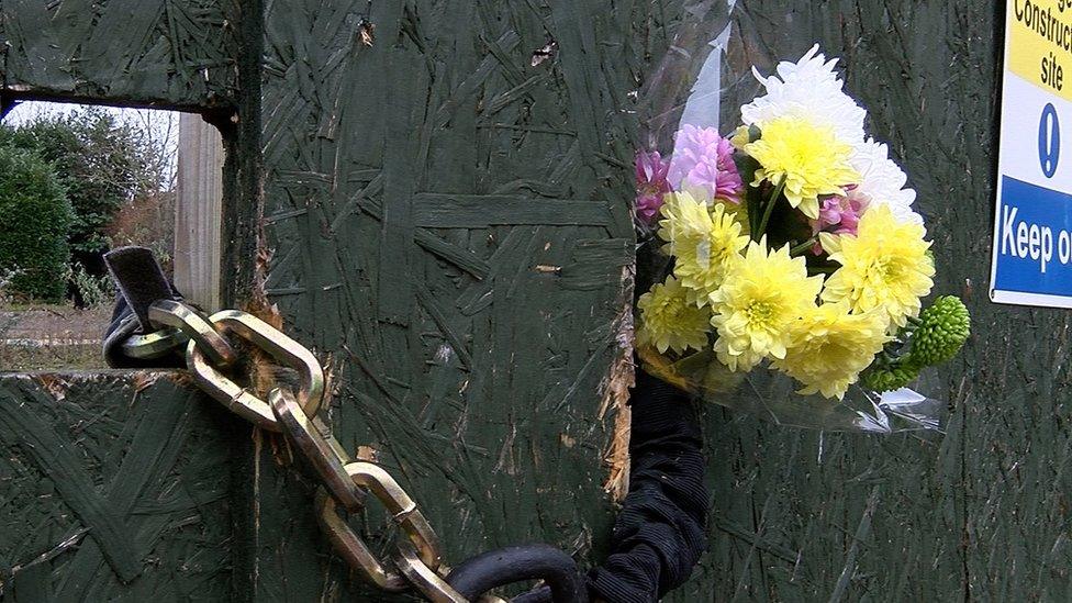 Flowers laid at the scene of the boarded up site on the second anniversary of the firs last week.