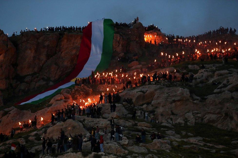 Iraqi Kurdish people carry fire torches up a mountain, as they celebrate Nowruz Day, a festival marking the first day of spring and the new year, in the town of Akra., near Duhok, in Iraqi Kurdistan, Iraq.