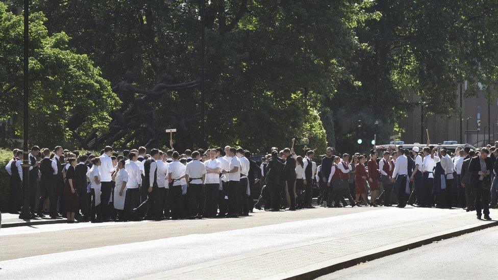 A group of staff members gathered in Hyde Park after they were led from the building