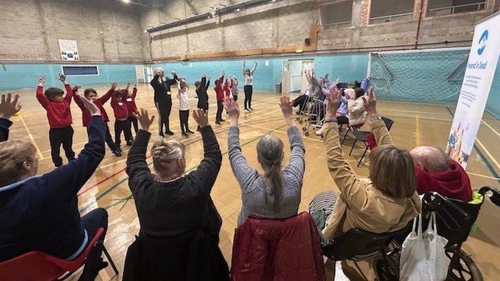 Care home residents taking part in activities with children