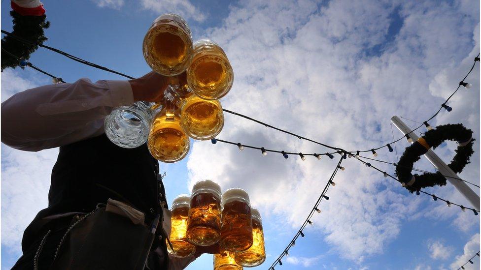 A waiter carries beers at the Theresienwiese fair grounds of the Oktoberfest beer festival in Munich, southern Germany, on September 20, 2015.