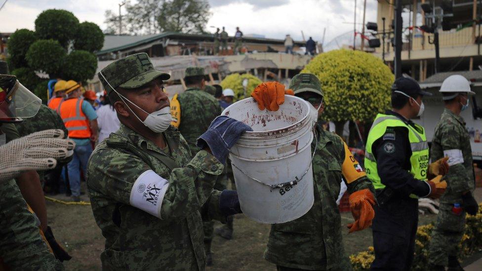 Rubble is removed, bucket-by-bucket, as rescue workers try to clear a path to any survivors at Enrique Rébsamen school, Mexico City, 20 September 2017