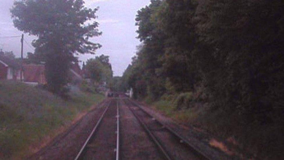 Forward-facing CCTV image from train 1V38 at 08:21:23 hrs. The crossing is 175 metres (8 seconds) ahead and pedestrians are visible