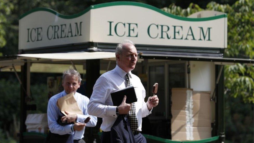 Man in suit eating ice cream.