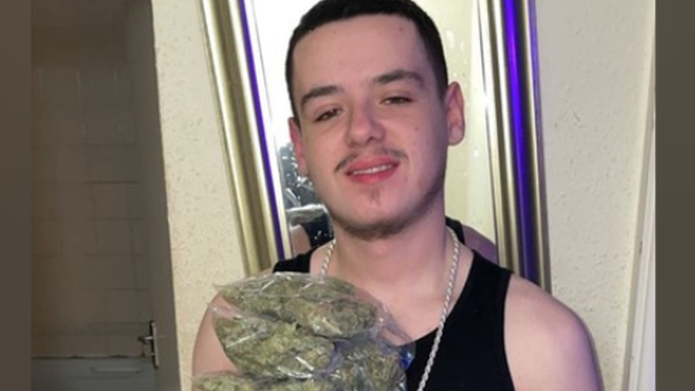 Elijah Clark holding bags of cannabis